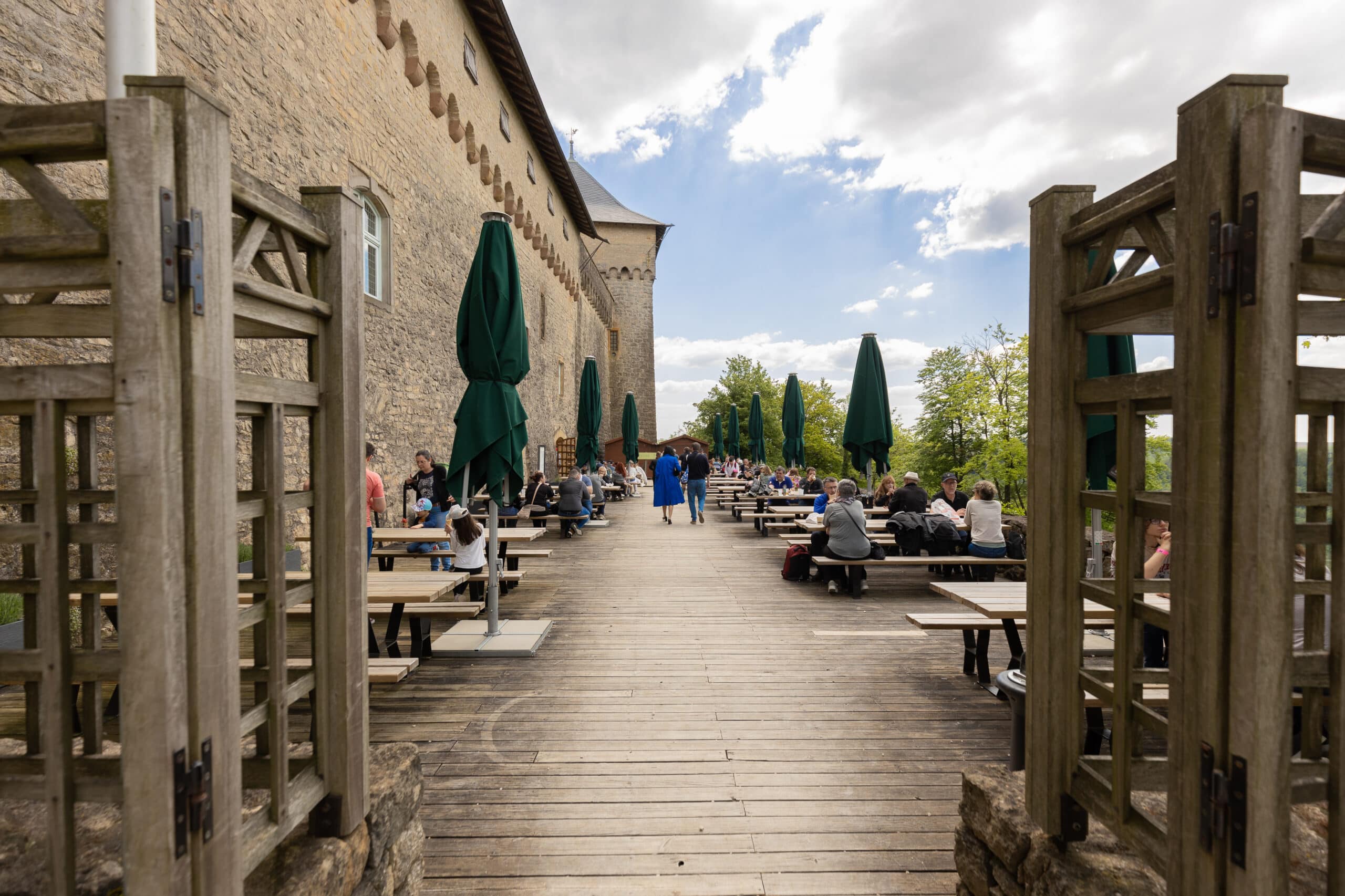 Photographie de la terrasse extérieure du Château de Malbrouck peuplée