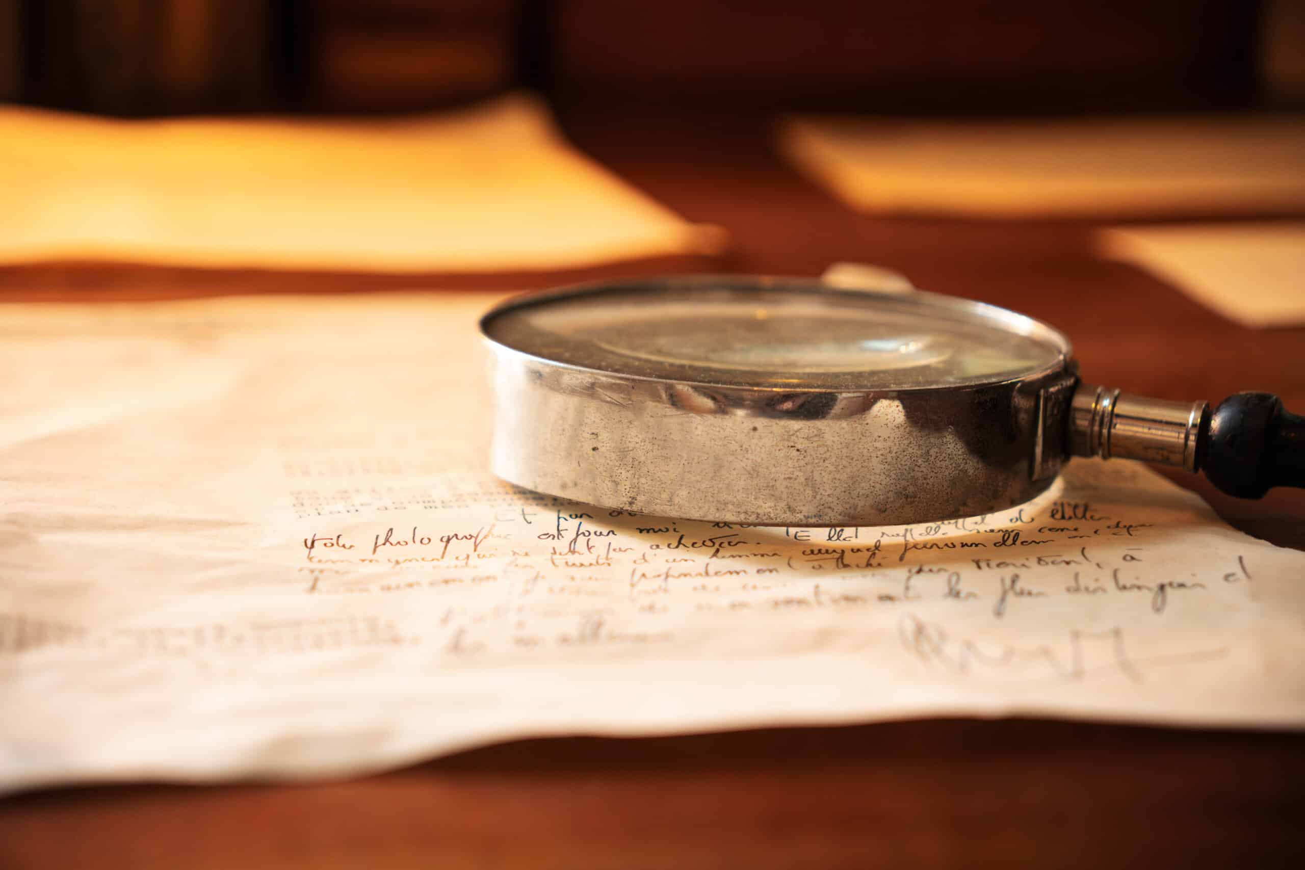 Image d'une lettre manuscrite et d'une loupe présentes dans la Maison de Robert Schuman