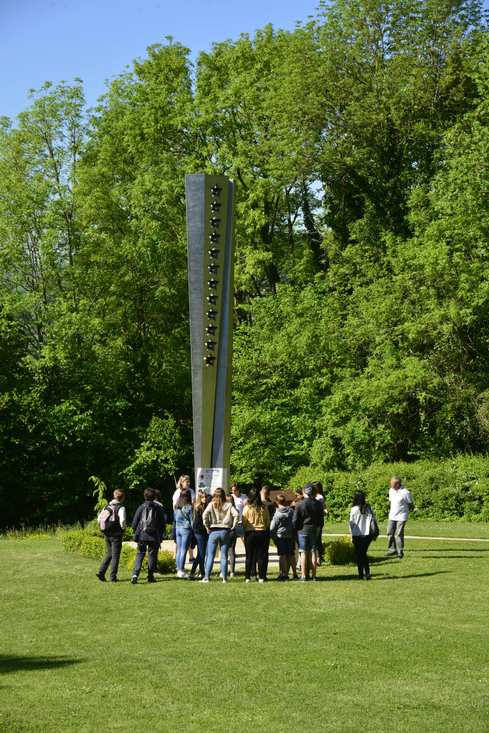 Photographie montrant une visite de la Maison de Robert Schuman à l'extérieur près d'un monument