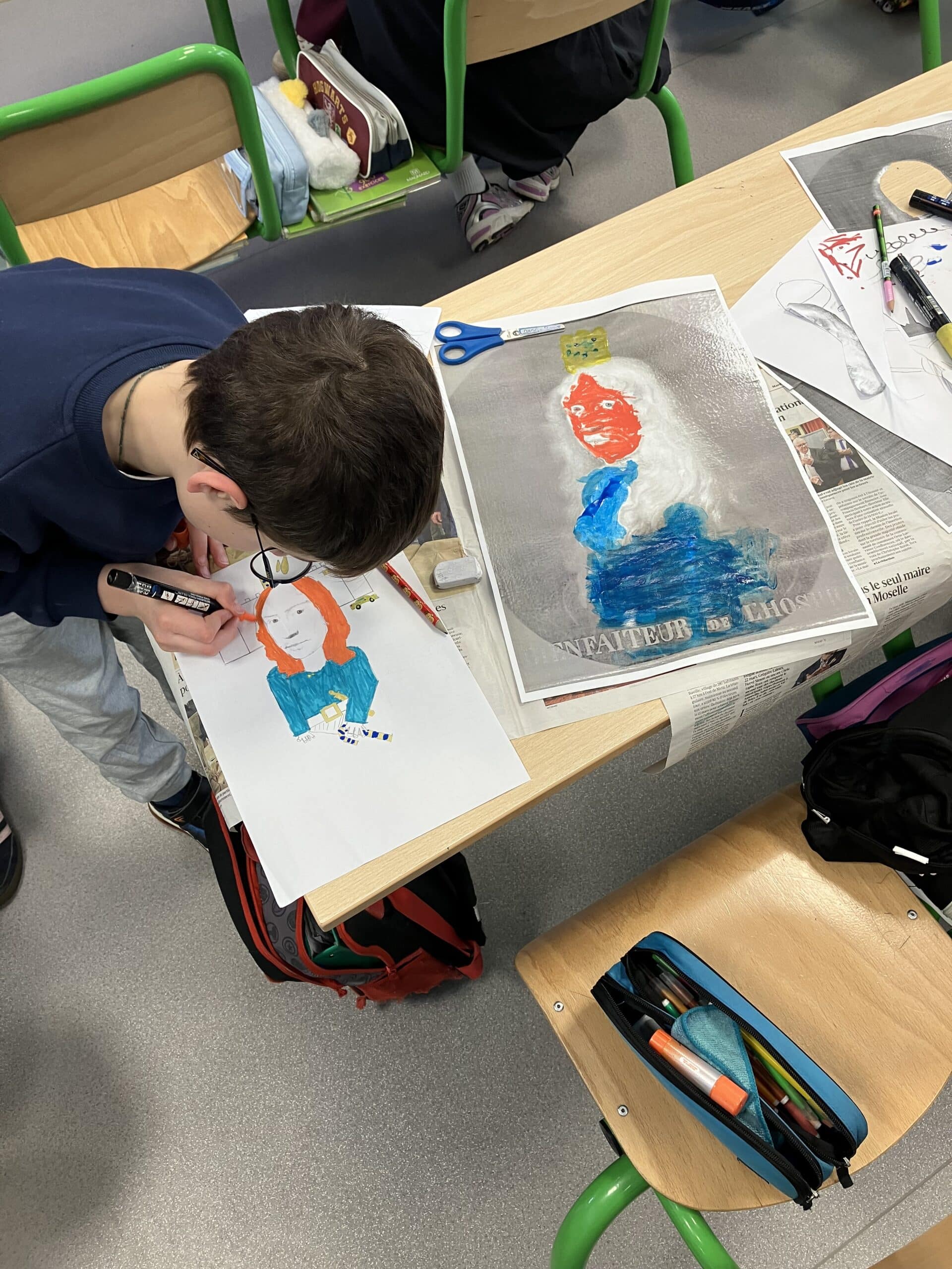 Photo présentant un élève en train de redessiner à sa façon une œuvre intitulée "Le bienfaiteur". C'est un homme de 17e siècle en portrait de 3/4 avec une longue perruque blanche et frisée.