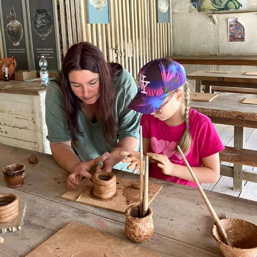 La potière et une enfant façonnent un petit vase